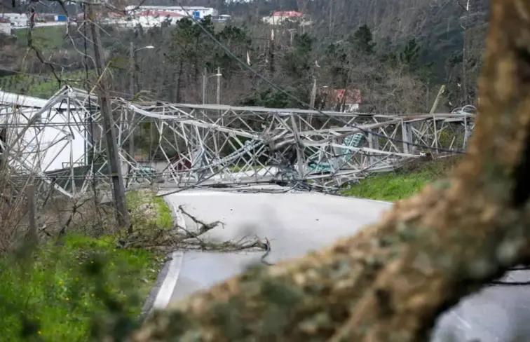 Um poste de alta tensão caído no meio da estrada.